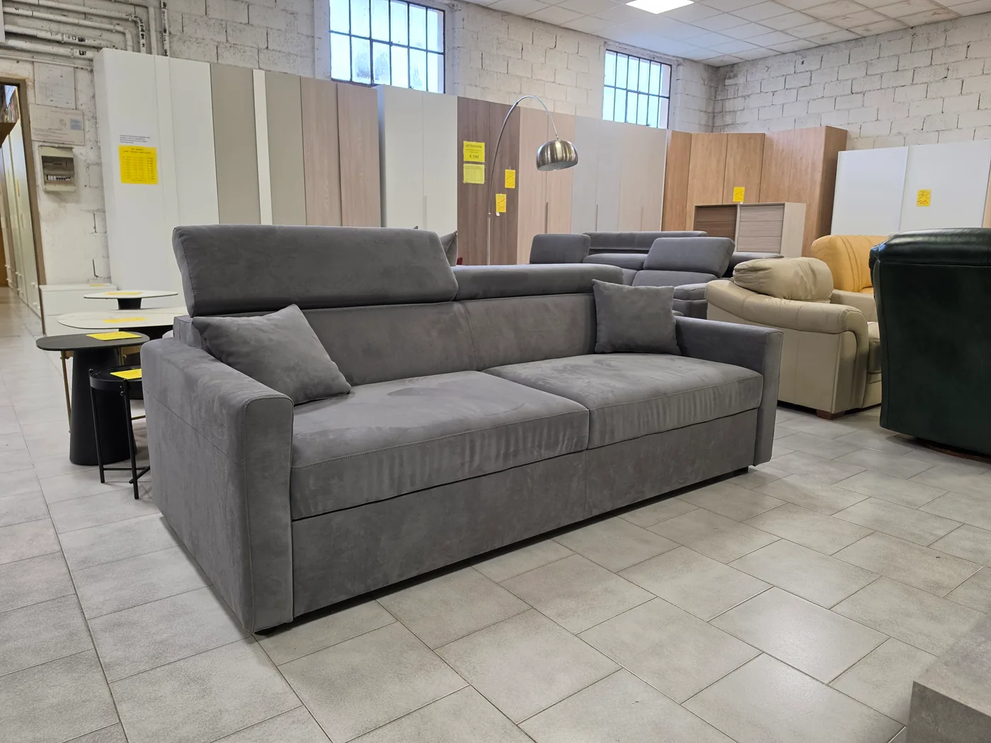 Divano grigio a tre posti in microfibra fotografato nello showroom
